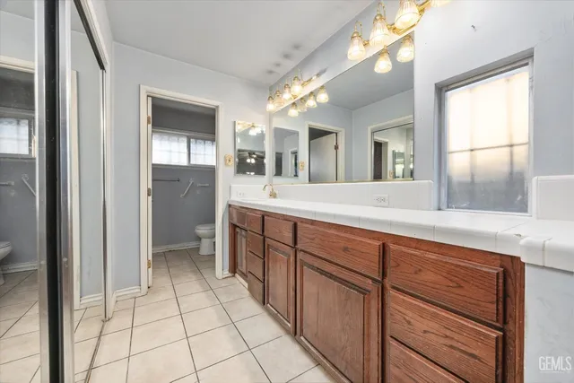 a spacious bathroom with a shower a sink and a mirror