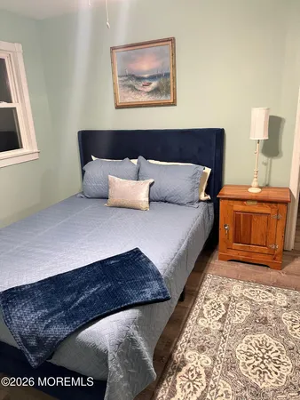 a large bedroom with a bed and wooden floor