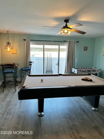 a room with pool table and windows