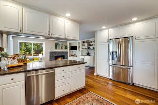 a kitchen with granite countertop stainless steel appliances a refrigerator and cabinets