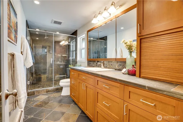 a spacious bathroom with a shower sink and mirror