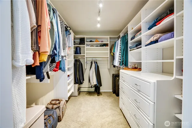 a view of walk in closet with clothes and shoes