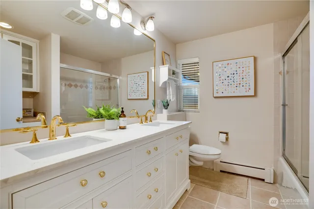 a bathroom with a double vanity sink mirror and toilet