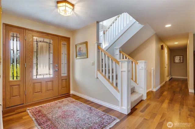 a view of a hallway with wooden floor and windows