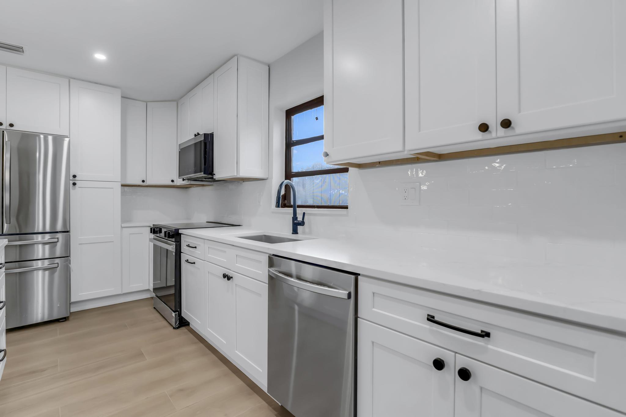 18089 103rd Trail South Boca Raton, FL 33498 - Photo 18 of 51 a kitchen with a sink stainless steel appliances and white cabinets