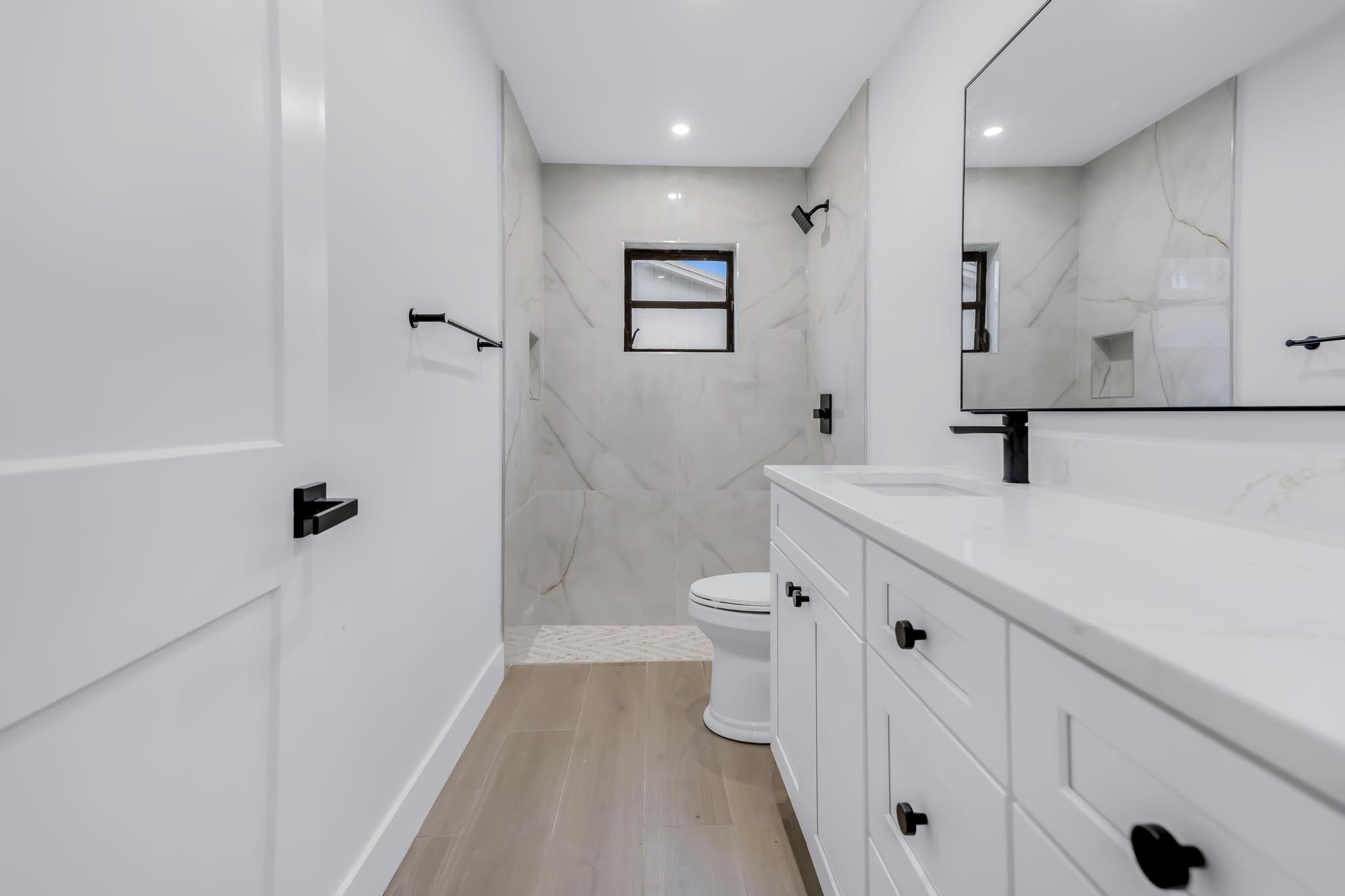 18089 103rd Trail South Boca Raton, FL 33498 - Photo 26 of 51 a bathroom with a sink a toilet a mirror and shower