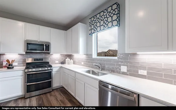 a kitchen with a sink stove and microwave
