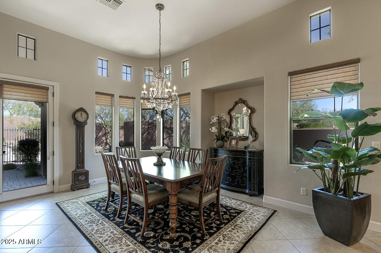 9190 East Hoverland Road Scottsdale, AZ 85255 - Photo 11 of 35 a dining room with furniture a rug and a chandelier