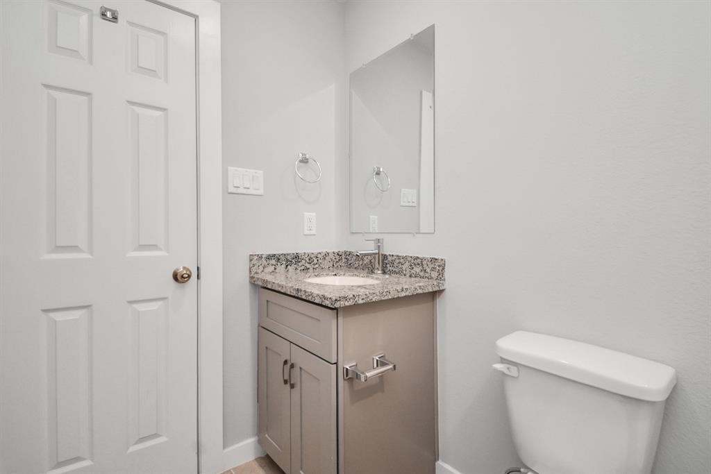 7413 Shotwell Street, Unit A Houston, TX 77028 - Photo 14 of 17 a bathroom with a granite countertop sink and a toilet