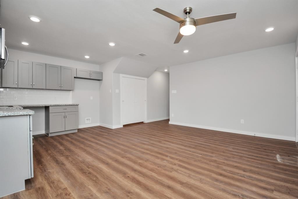 7413 Shotwell Street, Unit A Houston, TX 77028 - Photo 2 of 17 a view of an empty room with wooden floor and a ceiling fan