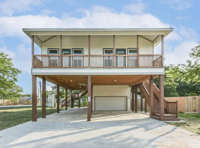 a view of a brick house with large windows and a small yard
