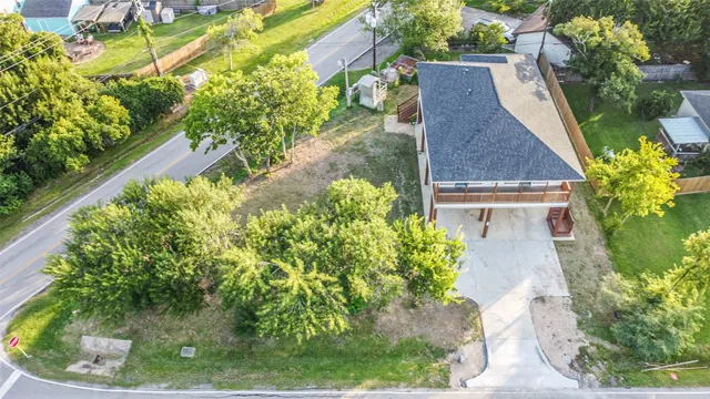 an aerial view of residential house with outdoor space and trees all around