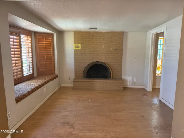 a view of an empty room with window and fire place
