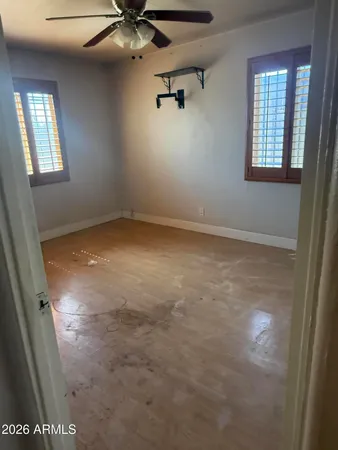 an empty room with windows and fan