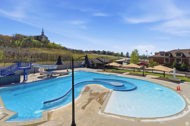 2007 Fielding Hill Lane Draper, UT 84020 - Photo 72 of 83 Outdoor pool complex featuring a large swimming pool with a distinct lazy river section, an integrated splash pad, and multiple water slides