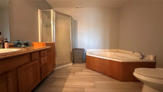 a bathroom with a granite countertop sink mirror vanity and toilet