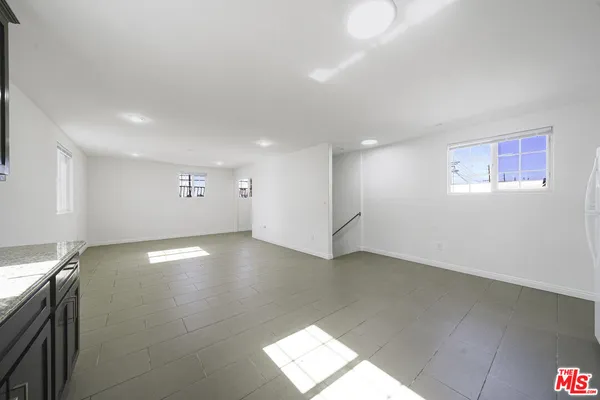 a view of empty room with wooden floor and windows