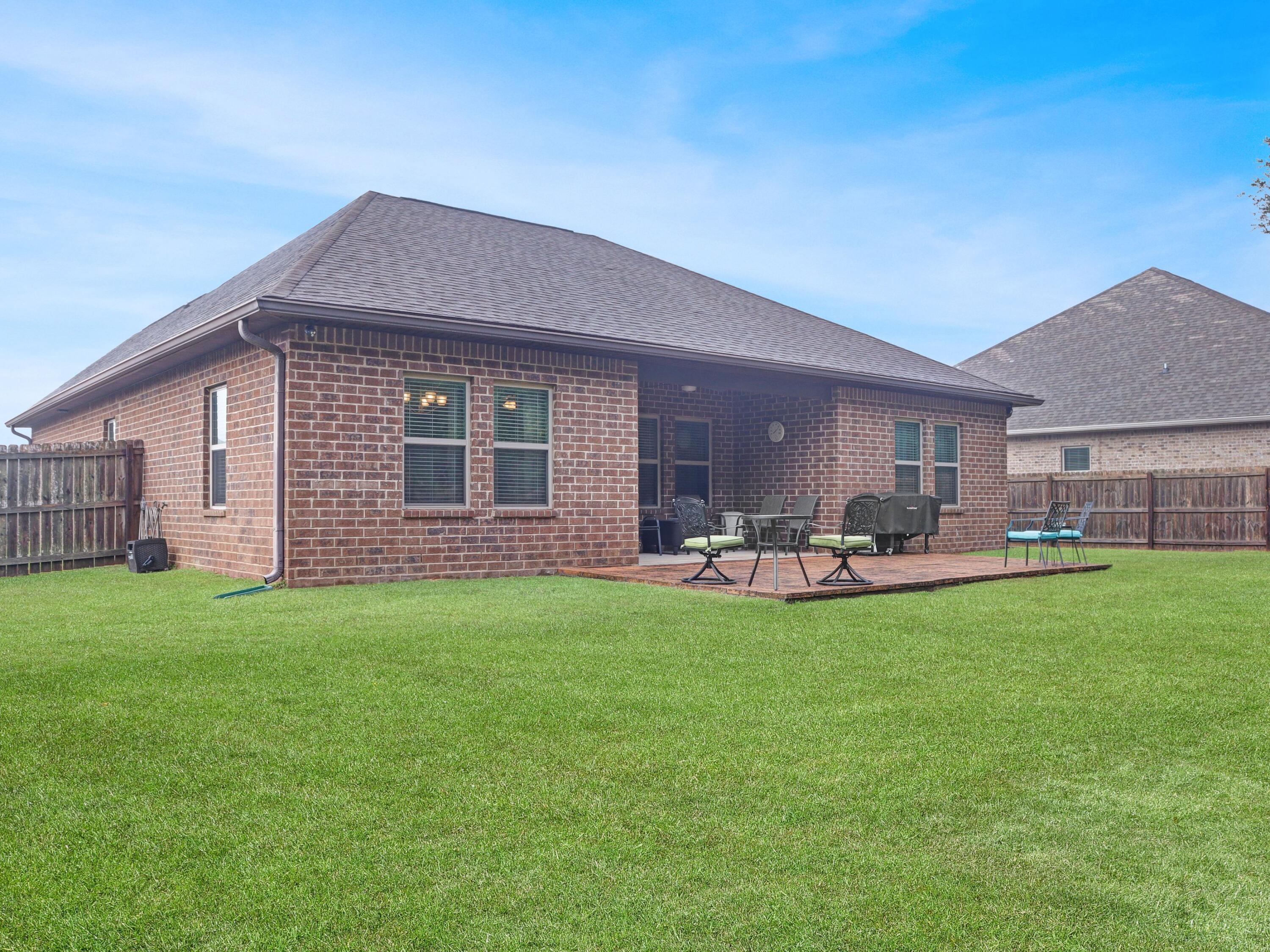 4753 Dupont Circle Pace, FL 32571 - Photo 42 of 42 a view of a house with a garden and patio