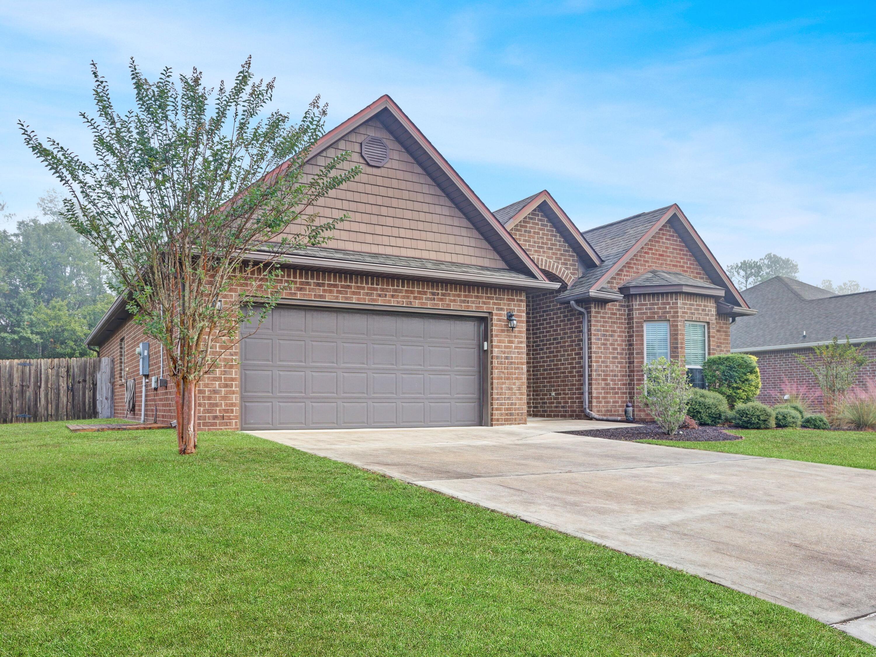 4753 Dupont Circle Pace, FL 32571 - Photo 6 of 42 a front view of a house with a yard and garage