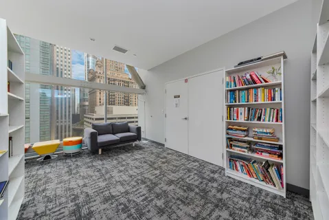 a living room with furniture and a book shelf