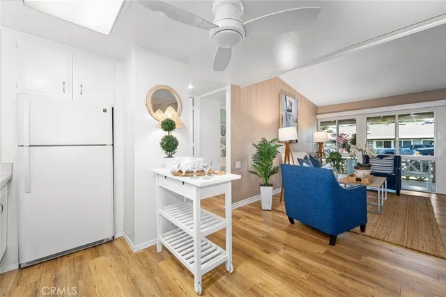 a living room with white cabinets and wooden floor
