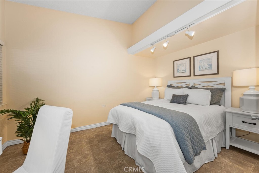 1121 Northwood Road, Unit 237D M9 Seal Beach, CA 90740 - Photo 29 of 45 a spacious bedroom with a bed and a lamp