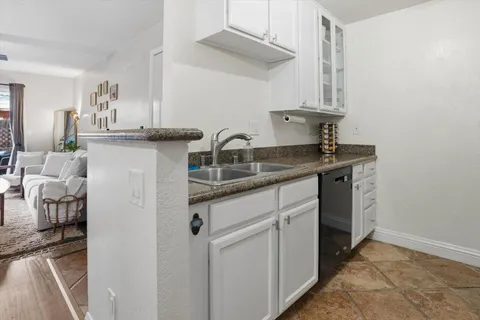 a kitchen with stainless steel appliances granite countertop a stove and a refrigerator with white cabinets