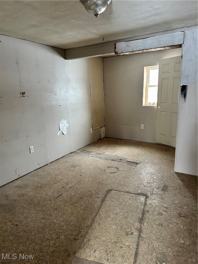 453 Lawn Street Geneva, OH 44041 - Photo 11 of 26 Spare room featuring a textured ceiling. Adjacent to garage and breezeway.