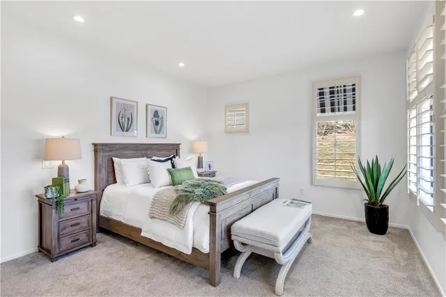 a spacious bedroom with a large bed and a potted plant