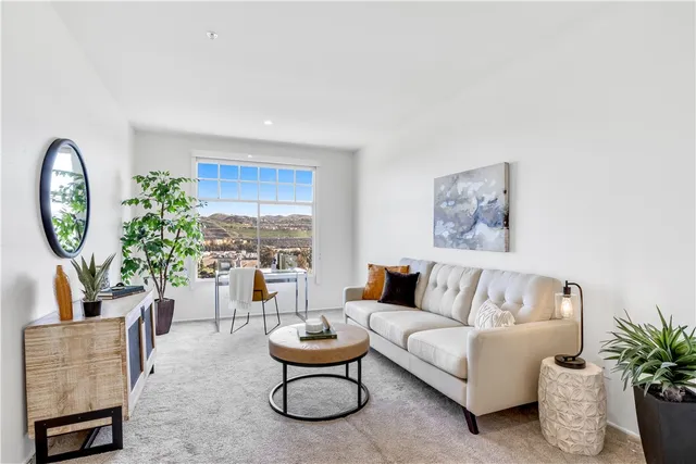 a living room with furniture a clock and a potted plant
