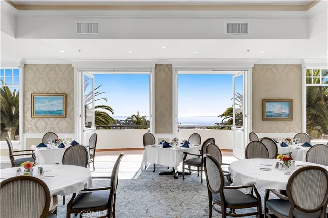 a room with lots of tables a large window and chairs