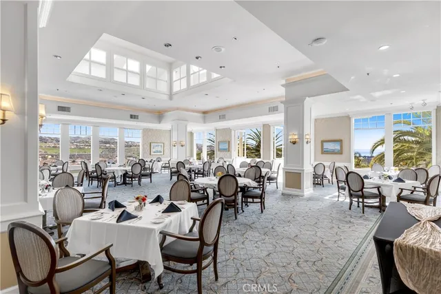 a dining room with furniture a chandelier and window