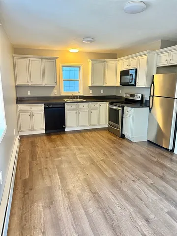 a large kitchen with granite countertop a stove a sink dishwasher and a refrigerator