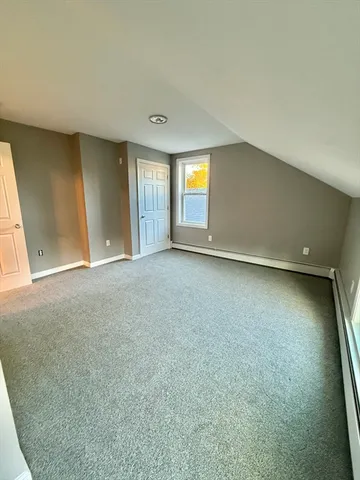 an empty room with a window and fireplace