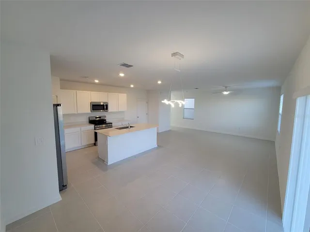 a view of kitchen with kitchen island and stainless steel appliances
