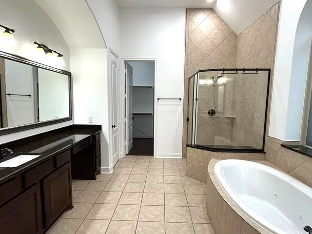a large bathroom with a bathtub and a double vanity sink