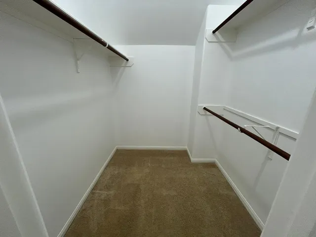 an empty room with wooden floor and ceiling fan