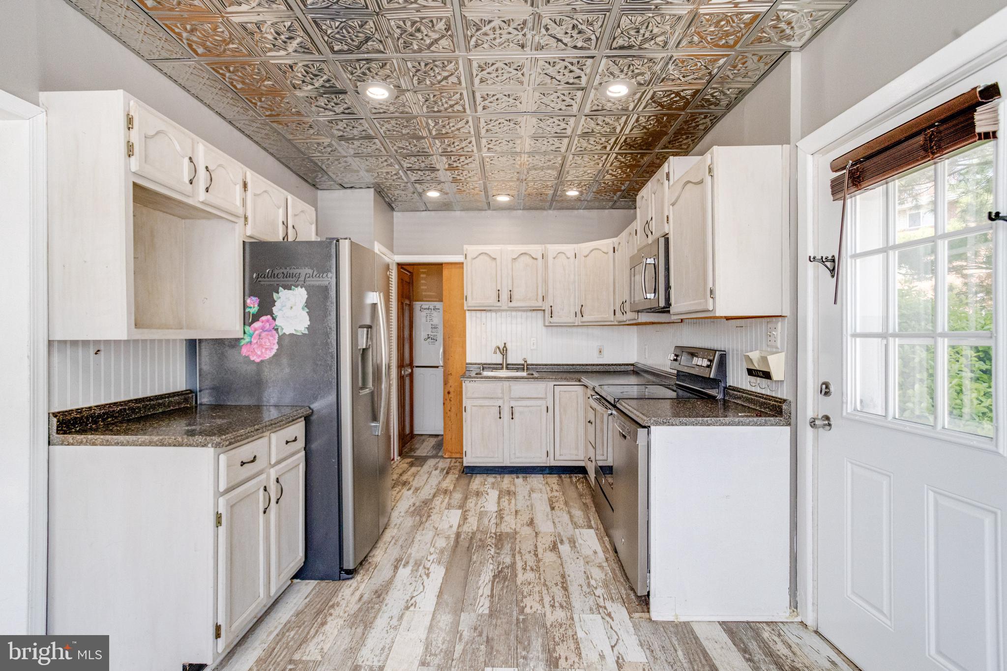 8421 Old Harford Road Parkville, MD 21234 - Photo 23 of 44 a kitchen with stainless steel appliances granite countertop a stove a sink dishwasher a refrigerator white cabinets and wooden floor