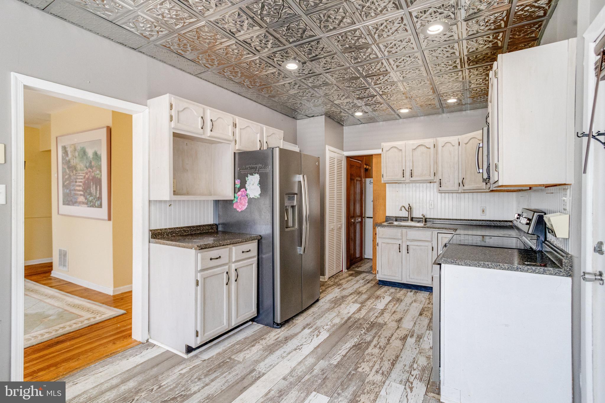 8421 Old Harford Road Parkville, MD 21234 - Photo 24 of 44 a kitchen with stainless steel appliances granite countertop a refrigerator a stove and a sink with wooden floor