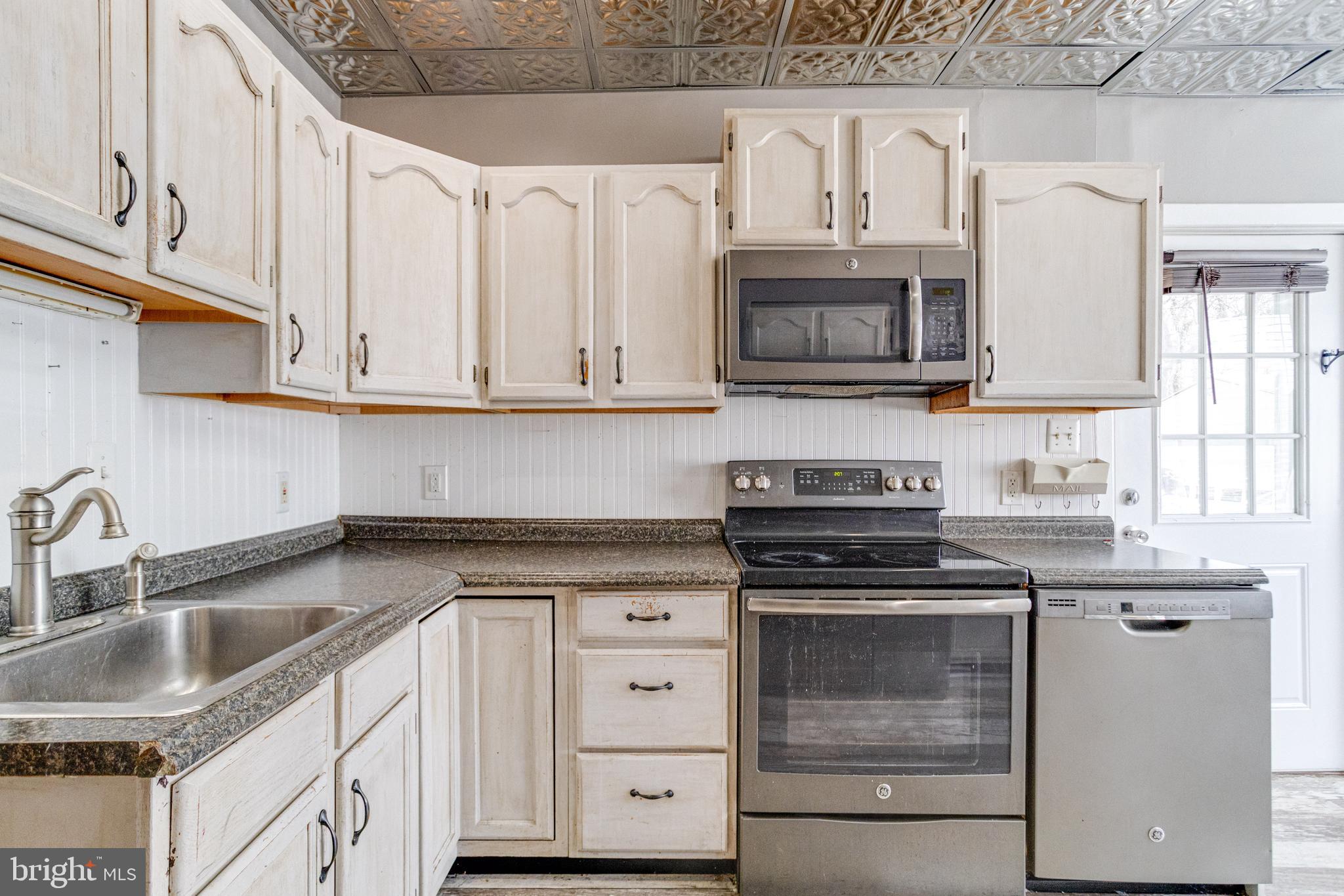 8421 Old Harford Road Parkville, MD 21234 - Photo 26 of 44 a kitchen with granite countertop a stove sink and cabinets