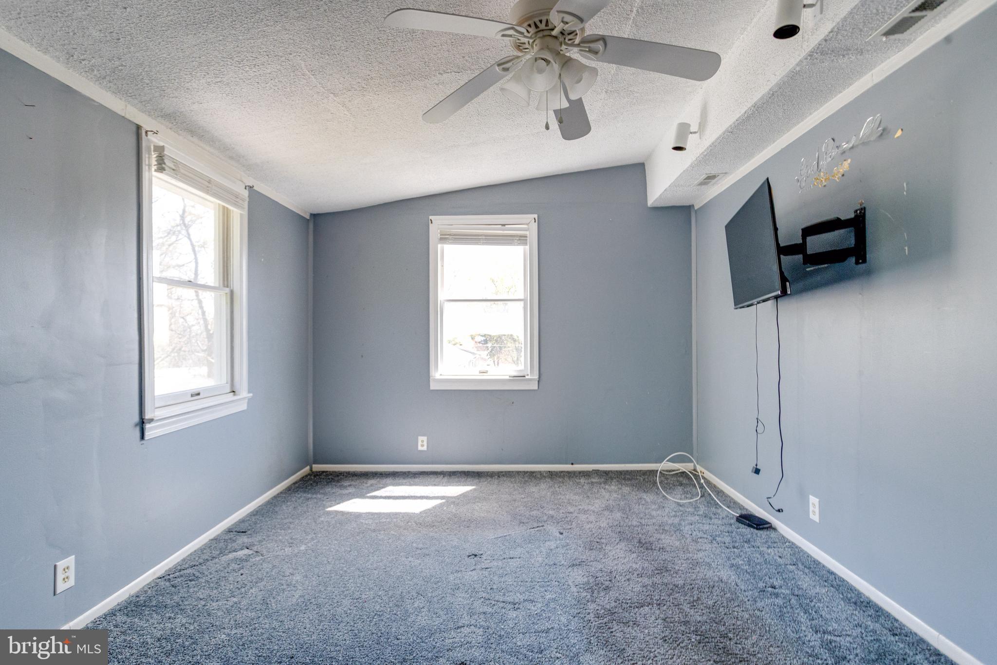 8421 Old Harford Road Parkville, MD 21234 - Photo 36 of 44 en empty room with windows and ceiling fan