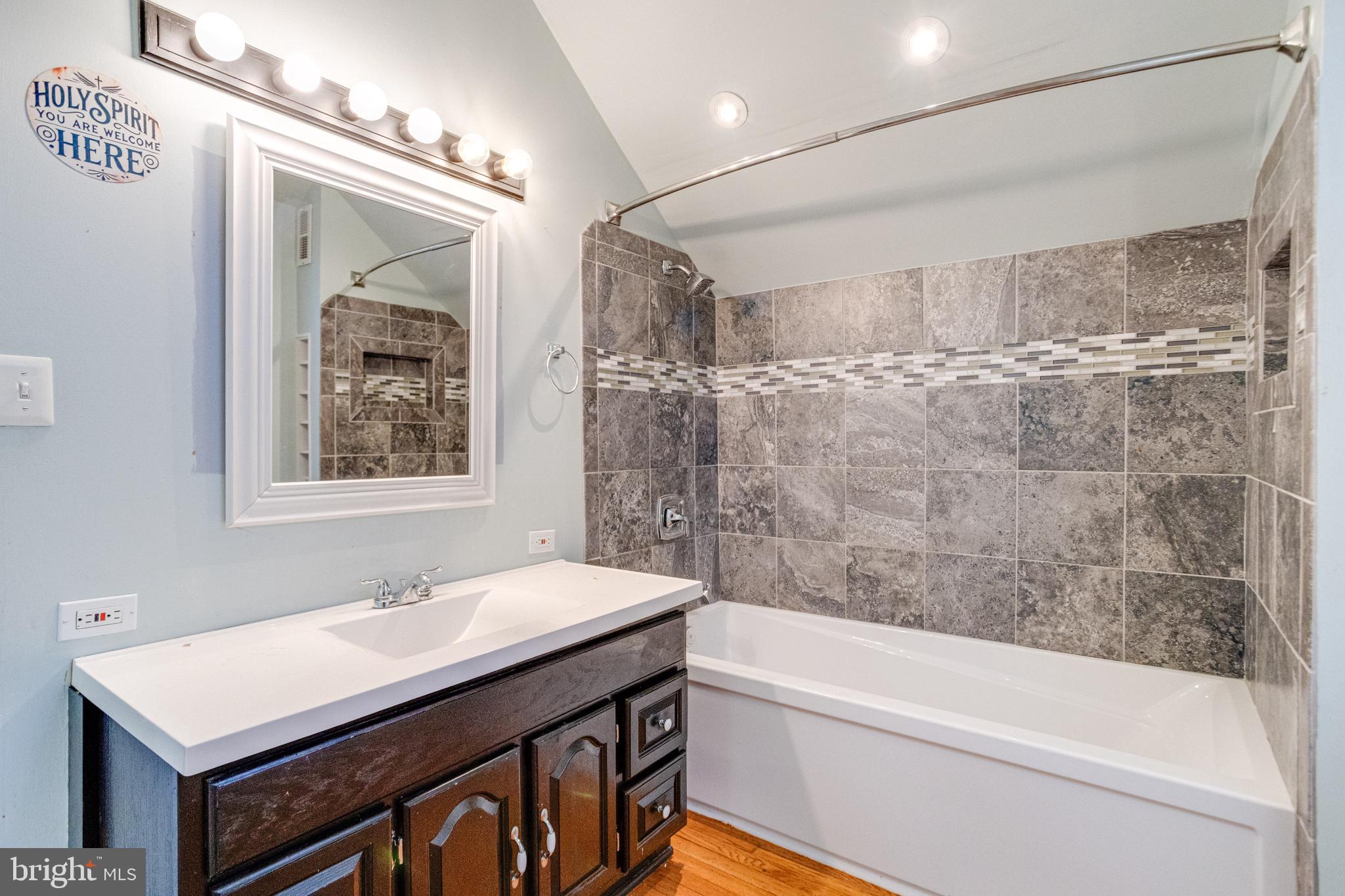 8421 Old Harford Road Parkville, MD 21234 - Photo 42 of 44 a bathroom with a sink a vanity and a bathtub
