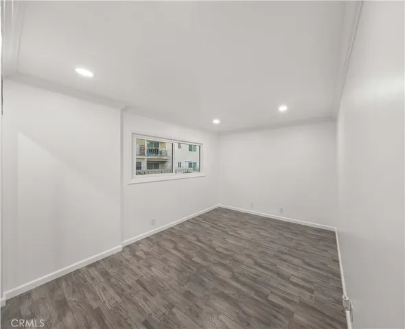 an empty room with a wooden floor and windows