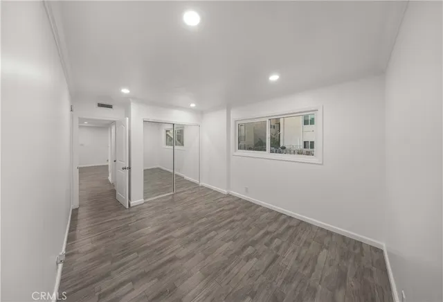 a view of empty room with wooden floor