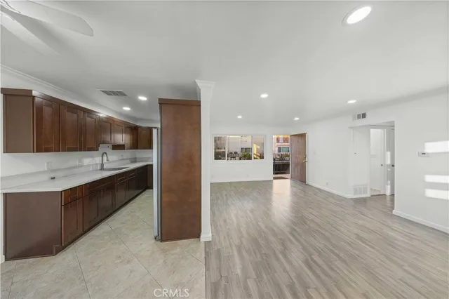 a large kitchen with a lot of counter space and wooden floor
