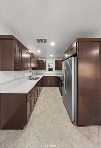 a large kitchen with stainless steel appliances kitchen island granite countertop a refrigerator and a sink