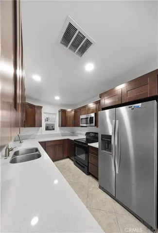 a kitchen with stainless steel appliances granite countertop a refrigerator and a sink