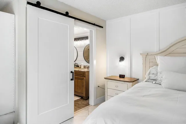 a bedroom with a bed and a refrigerator