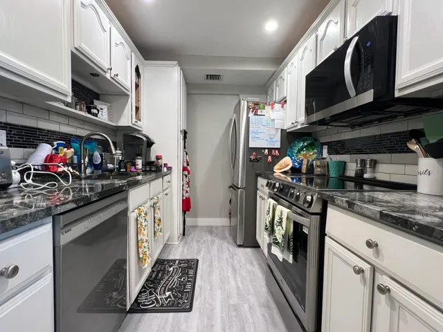 a kitchen with stainless steel appliances granite countertop stove and cabinets