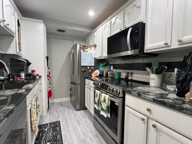 a kitchen with stainless steel appliances a stove a sink and a refrigerator